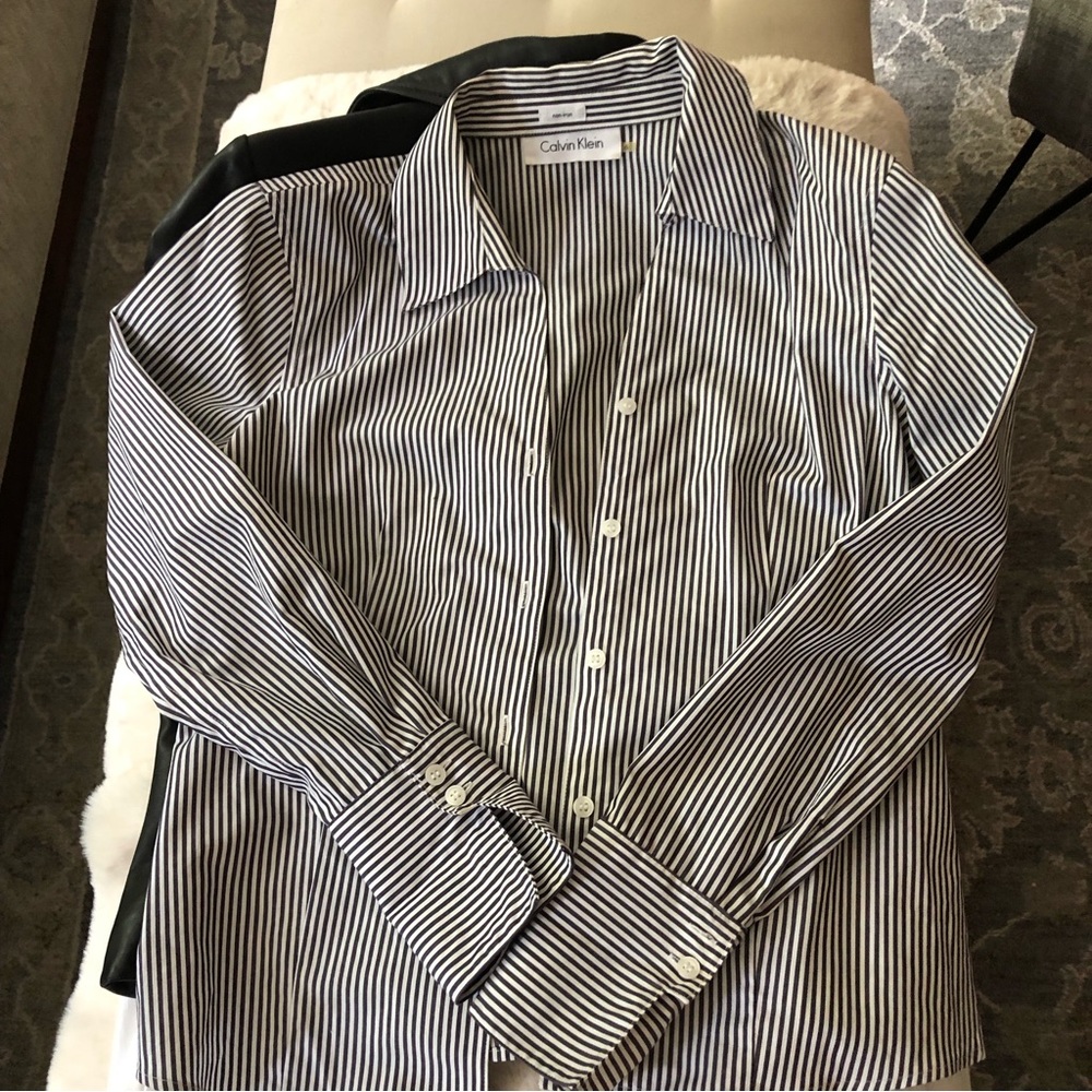 Not boxy. Flattering shape, easy to tuck in.Sleeves meant to be folded (cuffed)